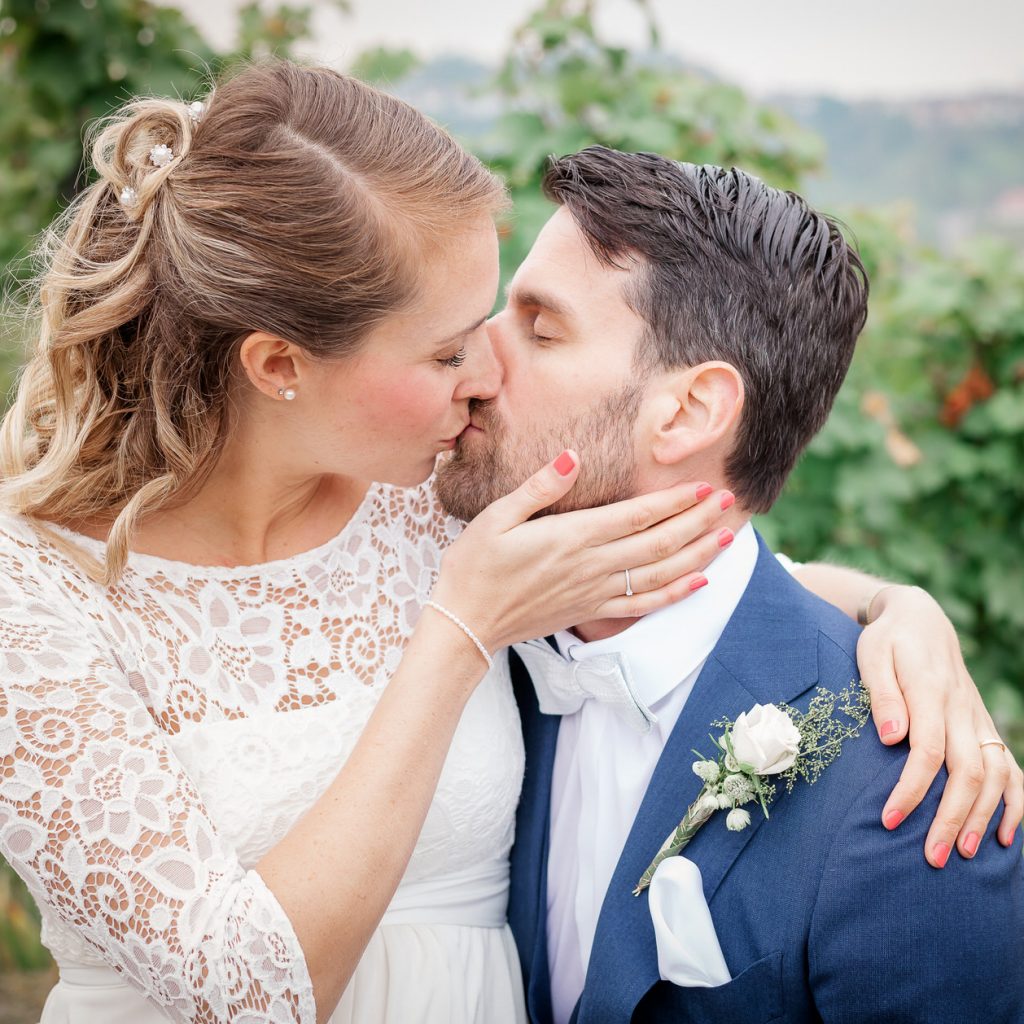 Braut küsst Bräutigam beim Paarshooting in den Weinbergen bei Esslingen