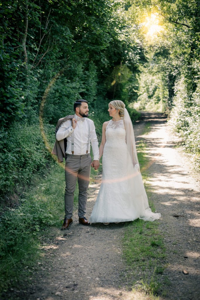 Brautpaar spaziert auf Feldweg bei Nürtingen mit Lichtreflex