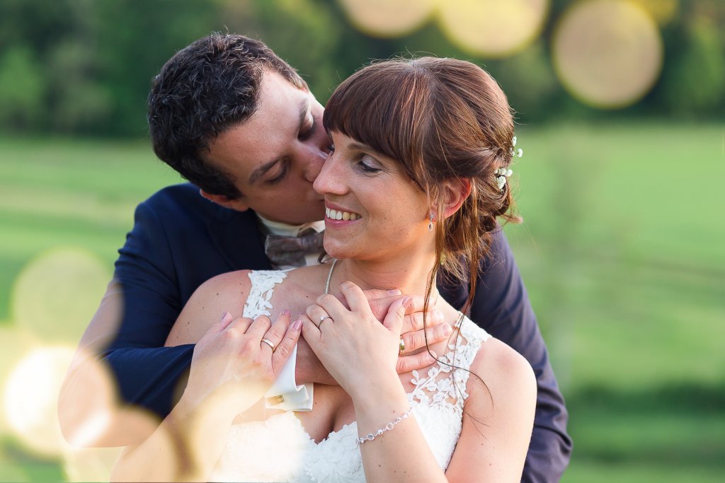 Sommerhochzeit Bräutigam küsst seine Braut zärtlich auf die Wange